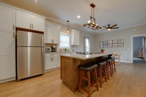 Sweet Southern Pines Abode with Yard and Covered Porch في سوثيرن باينس: مطبخ مع دواليب بيضاء وجزيرة كبيرة مع كراسي بار
