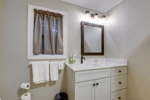 Sweet Southern Pines Abode with Yard and Covered Porch في سوثيرن باينس: حمام أبيض مع حوض ومرآة +16 صورة