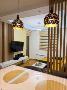 a living room with two pendant lights and a table at Prestige Forest Resort Zlatibor Wellness & Spa in Zlatibor