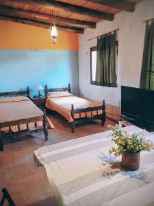 una camera con due letti e una TV a schermo piatto di El Espinillo2 a La Falda