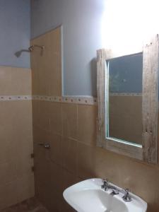 un bagno con lavandino e specchio di El Espinillo2 a La Falda Altre 12 foto