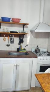 a kitchen with a sink and a stove at Lo de Vlady in Mina Clavero