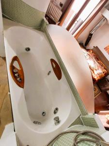 Una bañera blanca con tiradores de madera en un baño. en Casa nonna Gina, en San Francesco al Campo