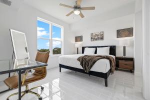 Luxury River Front Secluded Condo w Resort Amenities RFI 909 في Audubon: غرفة نوم بسرير ومكتب وطاولة زجاجية