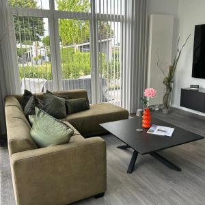 a living room with a couch and a coffee table at Luxus Chalet Time Out De Veerstal in Lathum