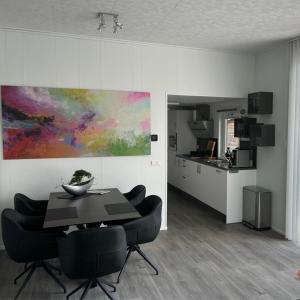 a dining room with a table and chairs and a kitchen at Luxus Chalet Time Out De Veerstal in Lathum