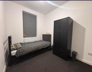 a bedroom with a bed and a dresser and a window at Near Manor Hospital Free Wifi in Walsall