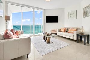 a living room with a couch and a table at Luxurious 2BD Condo with Direct Ocean Views & Resort Pool in Sunny Isles in Sunny Isles Beach