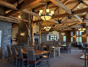 una sala da pranzo con tavoli e sedie e un muro di pietra di Stonewater Cove a Shell Knob