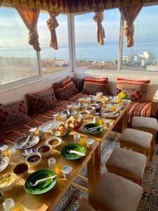 a table with plates of food on it in a room with windows at Talia Surf Morocco in Taghazout