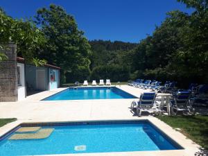 a swimming pool with lounge chairs and a swimming pool at Casa do Contador T3 / T6 in Vieira do Minho