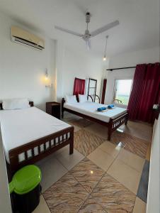 a large room with two beds and a couch at Athula Beach Front Hotel Hikkaduwa in Hikkaduwa