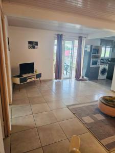 a living room with a television and a tiled floor at Chez Pascal in Terre-de-Haut