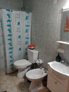 a bathroom with a toilet and a sink and a shower curtain at Cabañas Sprinter in Trapiche