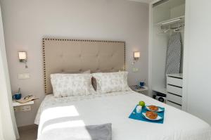 ein Schlafzimmer mit einem Bett, auf dem ein Tablett mit Essen steht in der Unterkunft Apartment Playa del Aguila NE/IM in Playa del Aguila + 12 Fotos