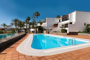 a swimming pool in front of a house at Apartment Playa del Aguila NE/IM in Playa del Aguila