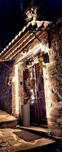 a brick building with a door with lights on it at Cozy Nest House Δίκορφο Ζαγορίου in Dikorfo