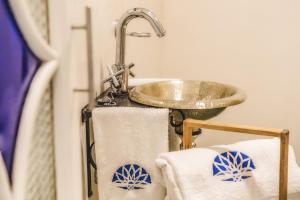 La salle de bains est pourvue d'un lavabo et de serviettes sur un portant. dans l'établissement Hotel Boutique Casa de Colón, à Séville 32 autres photos
