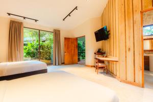 a bedroom with a bed and a desk and a television at Chachagua Rainforest Hotel & Hot Springs in Fortuna