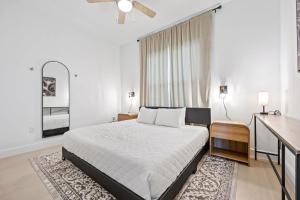 RIVER FLY-IN Luxury Condo w Views & Amenities RFI-1003 في Audubon: غرفة نوم بيضاء مع سرير كبير ومرآة +31 صورة