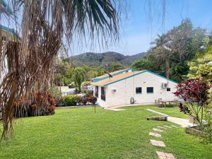 una casa bianca con il tetto blu su un cortile di Magnetic Reef 5 ad Arcadia