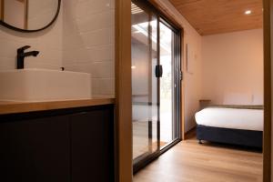 a bathroom with a sink and a bed in a room at Gull's Whisper - all you need in Falmouth