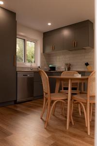 a kitchen with a wooden table and chairs at Gull's Whisper - all you need in Falmouth