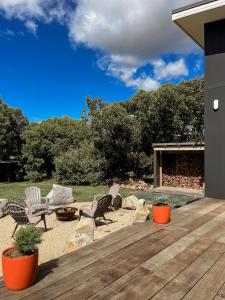 a deck with two chairs and a fire place at Gull's Whisper - all you need in Falmouth