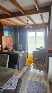 sala de estar con sofá y mesa y sala de estar con sofá en Cabaña Panguipulli - Sector Altos de Palguin, en Panguipulli 14 fotos más