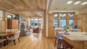 a kitchen and living room with a wooden ceiling at The Castle Rock Estate by AvantStay Steps From Arch Cape beach w Hot Tub Sauna in Arch Cape