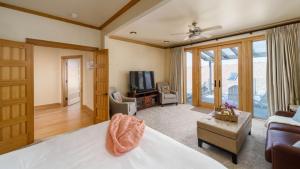 a bedroom with a bed and a tv and a couch at The Castle Rock Estate by AvantStay Steps From Arch Cape beach w Hot Tub Sauna in Arch Cape