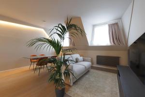 un salon avec un canapé blanc et une plante dans l'établissement Duomo Luxury Apartment XII, à Milan