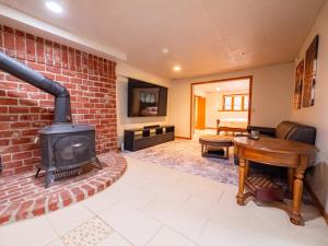 Country Stay 6 Min to Town with Deck & Jetted Tub في لورانس: غرفة معيشة مع موقد من الطوب وموقد خشبي