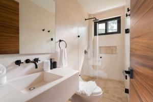 Chic Villa-Apartment in Aldea Zama, Private Pool & Security في تولوم: حمام أبيض مع حوض ودش +38 صورة