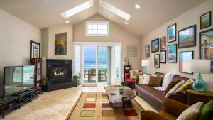 a living room with a couch and a fireplace at Moonlight by AvantStay Modern Home w Views Direct Access to Rockaway Beach in Rockaway Beach