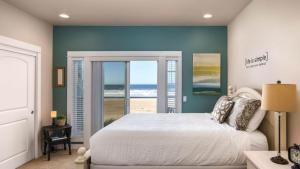 a bedroom with a bed and a view of the beach at Moonlight by AvantStay Modern Home w Views Direct Access to Rockaway Beach in Rockaway Beach