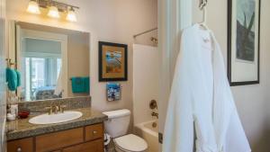 a bathroom with a sink and a toilet and a mirror at Moonlight by AvantStay Modern Home w Views Direct Access to Rockaway Beach in Rockaway Beach +19 photos