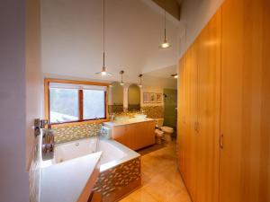 Country Stay 6 Min to Town with Deck & Jetted Tub في لورانس: حمام مع حوض استحمام ومغسلة ومرحاض +149 صورة