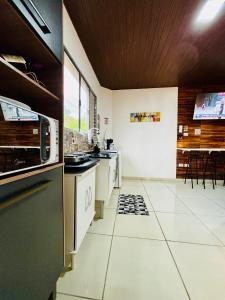 a kitchen with white tile flooring and a stove top oven at Hospedagem Marechal 02 in São Roque +19 photos