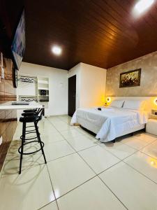 a bedroom with a large bed and a kitchen at Hospedagem Marechal 02 in São Roque