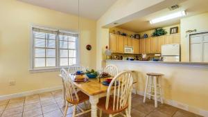 Place to Relax by AvantStay Shared Pool 3 Miles to Smathers Beach Month-Long Stays Only في ستوك آيلاند: مطبخ مع طاولة وكراسي وكاونتر