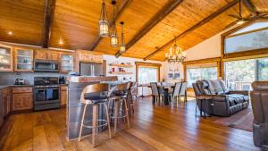 a kitchen and living room with wooden ceilings and a bar at Hot Tub Fire Pit Game Room Large Deck Views Angels Camp Lodge by AvantStay in Big Bear Lake
