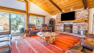 a living room with a fireplace and a tv at Hot Tub Fire Pit Game Room Large Deck Views Angels Camp Lodge by AvantStay in Big Bear Lake