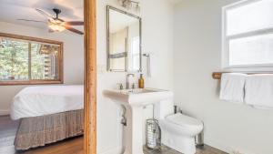a white bathroom with a sink and a toilet at Hot Tub Fire Pit Game Room Large Deck Views Angels Camp Lodge by AvantStay in Big Bear Lake +39 photos