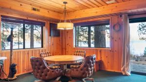 a dining room with a wooden table and chairs at Shoreline Lakehouse by AvantStay Majestic Lakefront Cabin w Hot Tub Fire Pit in Big Bear Lake
