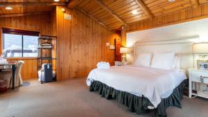 a bedroom with a large bed in a wooden room at Shoreline Lakehouse by AvantStay Majestic Lakefront Cabin w Hot Tub Fire Pit in Big Bear Lake