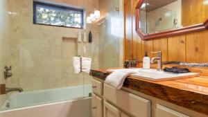 a bathroom with a sink and a shower and a tub at Shoreline Lakehouse by AvantStay Majestic Lakefront Cabin w Hot Tub Fire Pit in Big Bear Lake