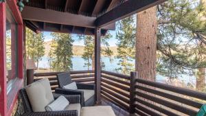 a porch with chairs and a view of a lake at Shoreline Lakehouse by AvantStay Majestic Lakefront Cabin w Hot Tub Fire Pit in Big Bear Lake