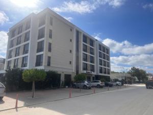 克兰内沃Hotel Magnific的白色的建筑,有汽车停在停车场