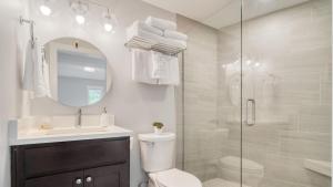 a bathroom with a shower and a toilet and a sink at Sunset Cove by AvantStay Beachfront w Balcony in Arch Cape +31 photos